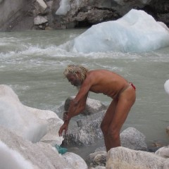 Sadhu se koupe v pramenu gangy Gomukh v ledovcové vodě